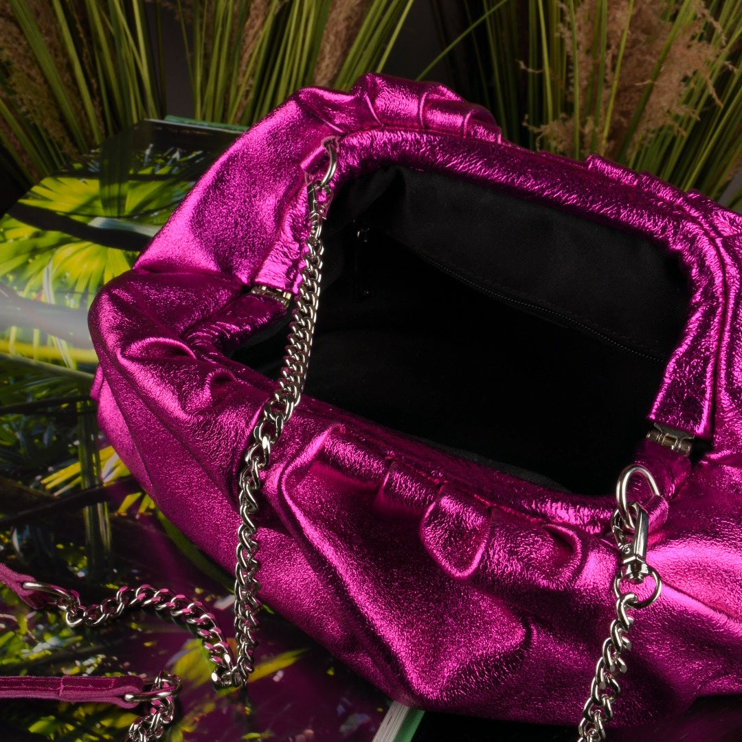 Inside of a metallic pink clutch bag with removable silver straps